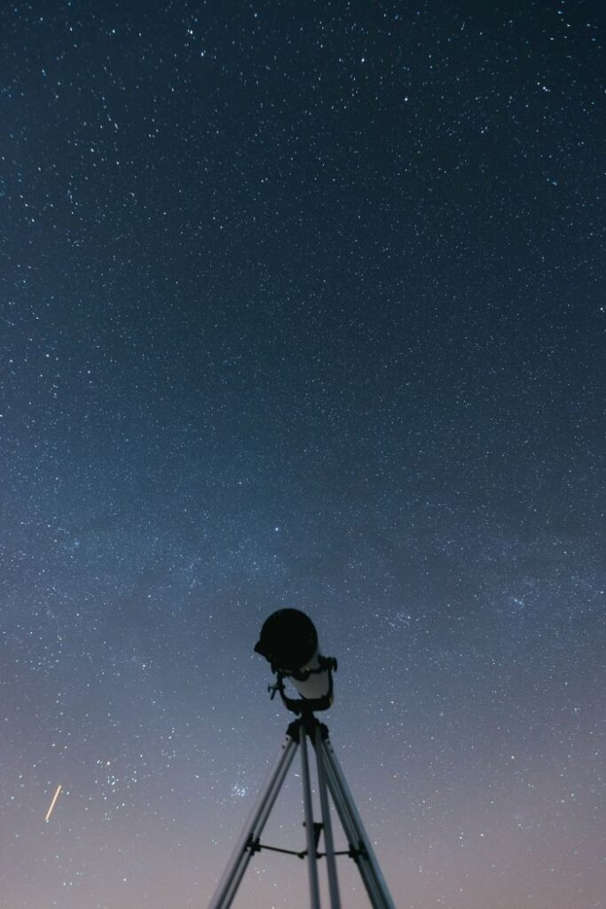 Silhouette of a telescope under a star-filled night sky. A perfect shot for astronomy enthusiasts.